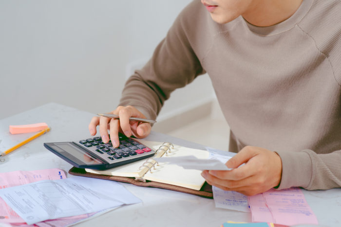 Man calculating his consumer debt at a desk